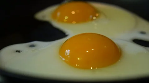 Eggs Frying in a pan Stock Footage 101284403