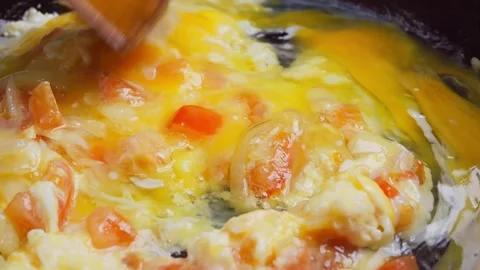 Eggs in a frying pan with tomatoes and onions are fried with spices. Medium.. Stock Footage 262478426
