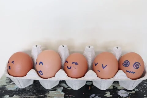 Eggs with funny faces in box. Happy, angry, sad, surprised faces on brown eggs. Stock Footage 332162982