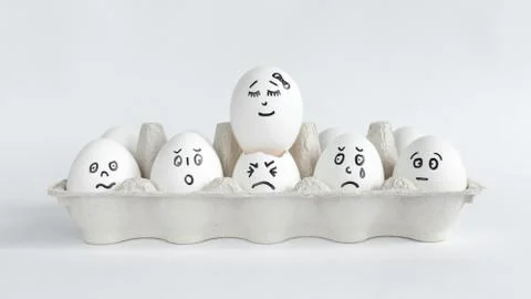 Eggs with funny faces in the package on a white background. Easter Concept . Foto stock