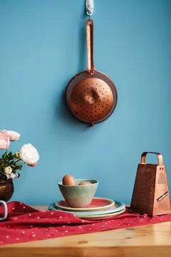 Eggs on a kitchen table next to flowers and a grater Stock Photos