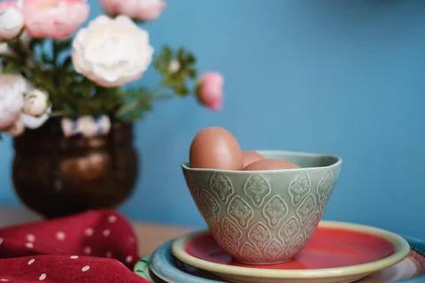Eggs on a kitchen table next to flowers Stock Photos