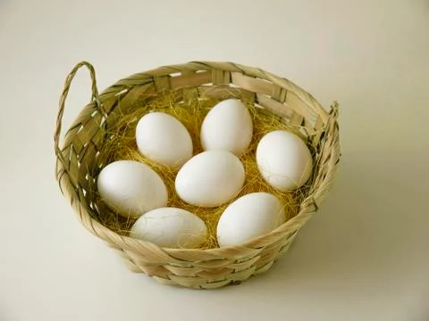 Eggs in a large basket on a light background. Stock Photos