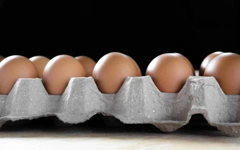 Eggs in package on table with black background Stock Photos