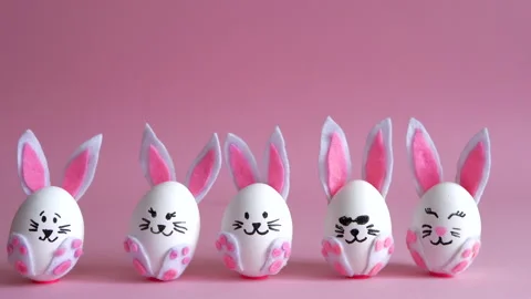 Eggs painted as rabbits with different emotions on a pink background. Stock Footage 149604081
