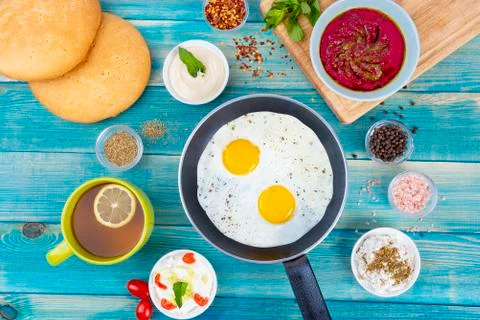 Eggs in Pan with Bread and Hummus and Labneh with Cup of Tea with Limon. Fotos Stock