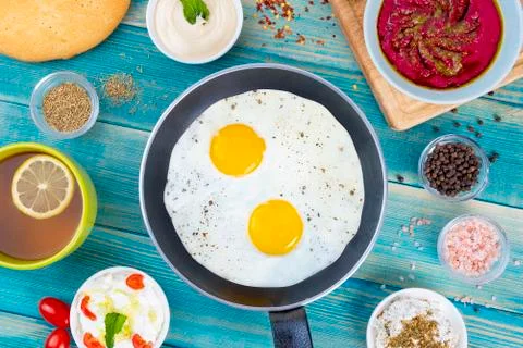 Eggs in Pan with Bread and Hummus and Labneh with Cup of Tea with Limon. Fotos Stock