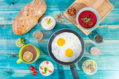 Eggs in Pan with Bread and Hummus and Labneh with Cup of Tea with Limon. Fotos Stock
