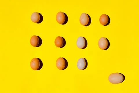 An eggs pattern. A different sizes eggs on a yellow background. Stock Photos