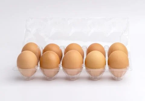 Eggs in a plastic box on the white background Stock Photos