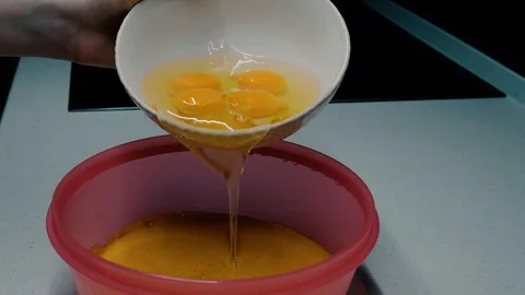 Eggs poured into a bowl Stock Footage 127699676