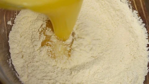 Eggs pouring into flour. Stock Footage 88529604