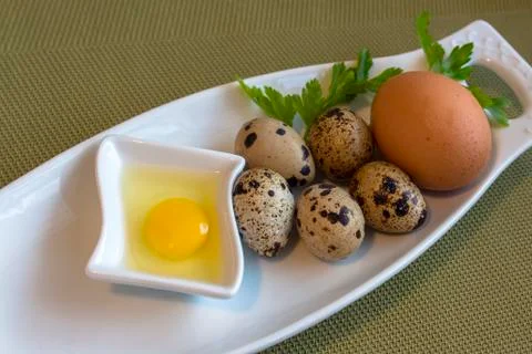 Eggs from quail - a raw and roasted. And a hen egg. Stock Photos