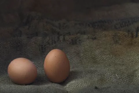 Eggs on sackcloth background Stock Photos