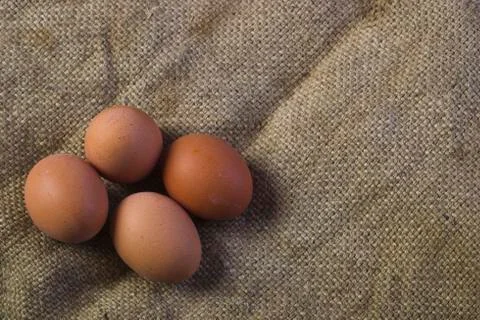 Eggs on sackcloth background Stock Photos