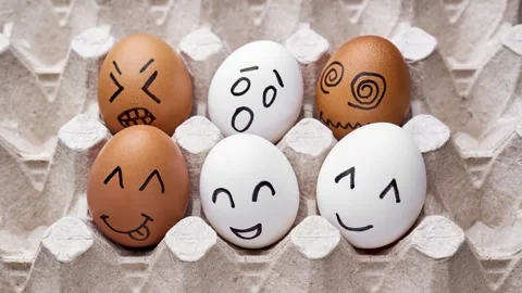 Eggs with sad and happy faces. Cute eggs with funny faces. Stop motion. Video stock 303704124