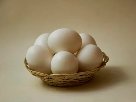 Eggs in a small basket on a light background. Stock Photos