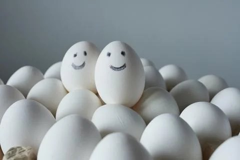 Eggs with smiley faces on colored background, close-up. Stock Photos