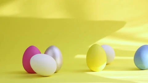 Eggs stand on a yellow background, a person's hand takes an Easter egg. Stock Footage 234713867