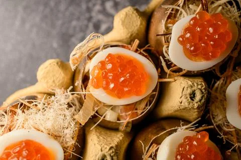 Eggs stuffed with red caviar serving in golden shell 스톡 사진