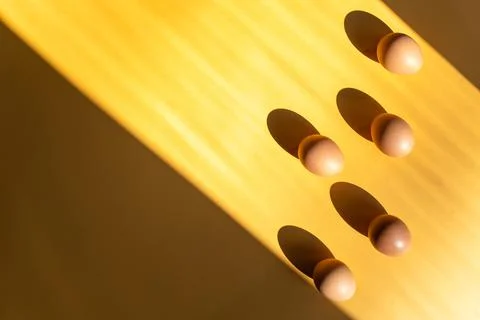 Eggs on the table isolated on yellow background. Lights and shadows play. 스톡 사진
