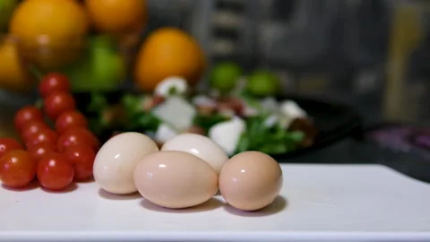 Eggs tomatoes salad Fresh white eggs displayed in a woven basket on a wooden Stock Footage 316299531