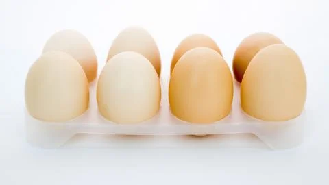Eggs in a tray on a white background Stock Photos