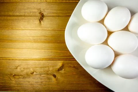 Eggs on a while plate sitting on the kitchen table waiting to be cracked Stock Photos
