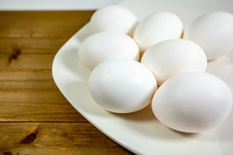 Eggs on a while plate sitting on the kitchen table waiting to be cracked Stock Photos