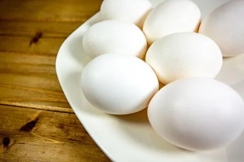 Eggs on a while plate sitting on the kitchen table waiting to be cracked Stock Photos