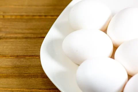 Eggs on a while plate sitting on the kitchen table waiting to be cracked Stock Photos