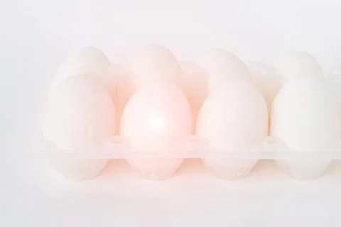Eggs on white background, one of the eggs is infected with salmonella, close-up Foto stock