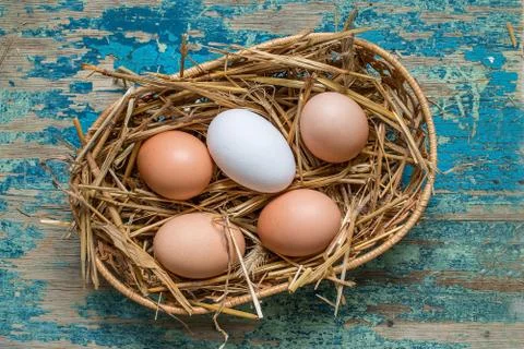 Eggs in wicker basket on table close-up Stock Photos