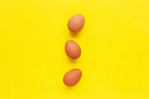 Eggs on yellow background. Stock Photos