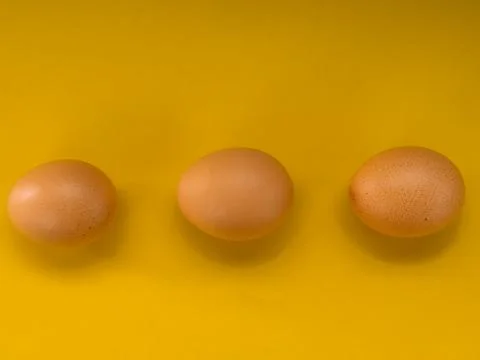 Eggs on a yellow background Stock Photos