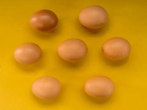 Eggs on a yellow background Stock Photos