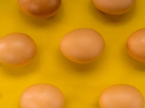 Eggs on a yellow background Stock Photos