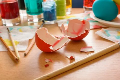 Eggshell among the set for coloring eggs: brushes, paints, napkins. Stock Photos