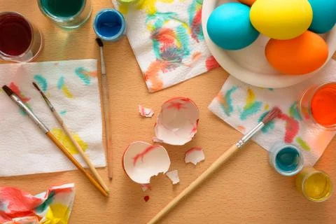Eggshell among the set for coloring eggs: brushes, paints, napkins Stock Photos
