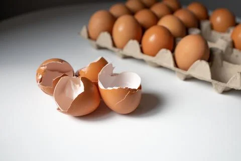 Eggshells and eggs in a paper tray on white table Foto stock