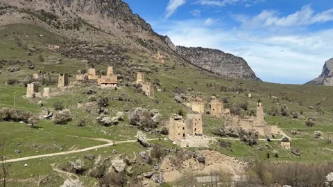 The Egikal tower complex stands among green hills in a mountain area surrounded Stock Footage 338001127