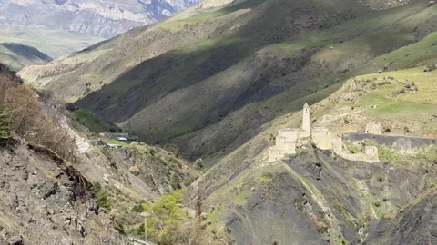 The Egikal tower complex stands in a mountain valley near a winding road with Stock Footage 335076778