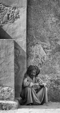 Egyptian man in traditional clothes sitting in temple, Karnak, Egypt Stock Photos