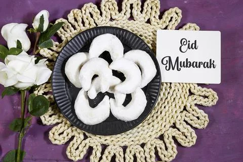 Eid Mubarak Celebration With White Crescent Cookies, Roses, Platter, And Woven M Stock Photos