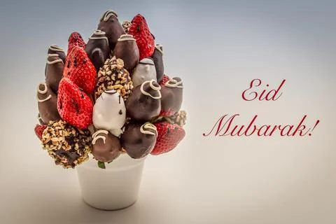 Eid Mubarak greeting card with red lettering; A bundle of edible flowers, arr Stock Photos