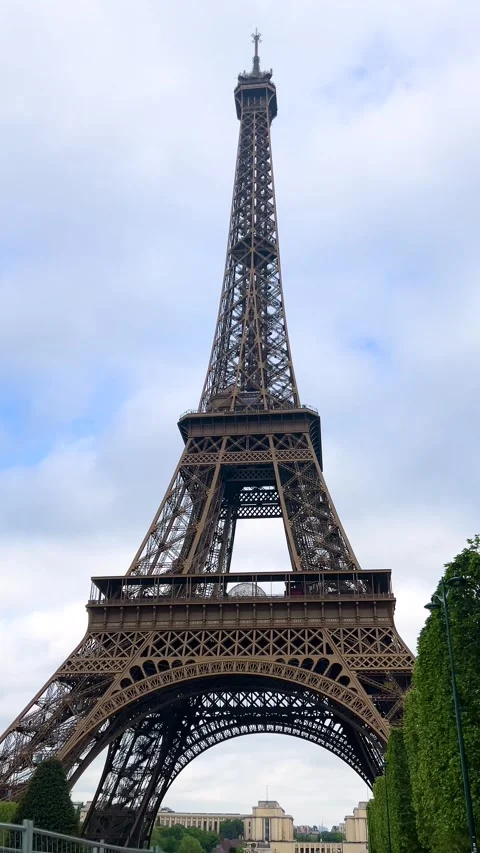 Eiffel Tower and green trees against the sky in spring in Paris, France.  Stock Footage 311942782
