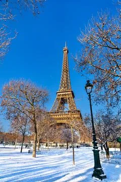 Eiffel Tower and lamp post in snowy Champ de Mars park in Paris Stock Photos