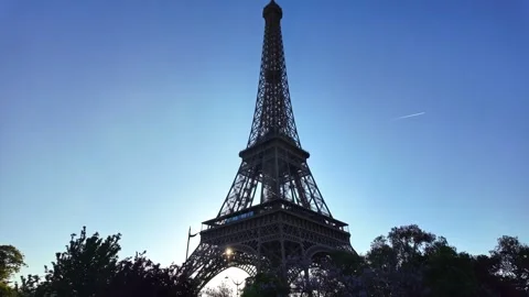 Eiffel Tower backlit by sun at sunrise in Paris, France. Low angle pov, copy Stock Footage 336250662