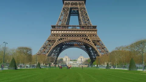 Eiffel tower base green lawn people walking Paris handheld shot Stock Footage 340550281