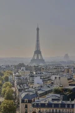 Eiffel Tower close view above Paris rooftops in atmospheric haze Stock Photos